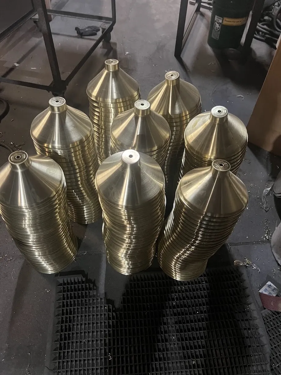 Spun brass lamp shades stacked for a lighting customer